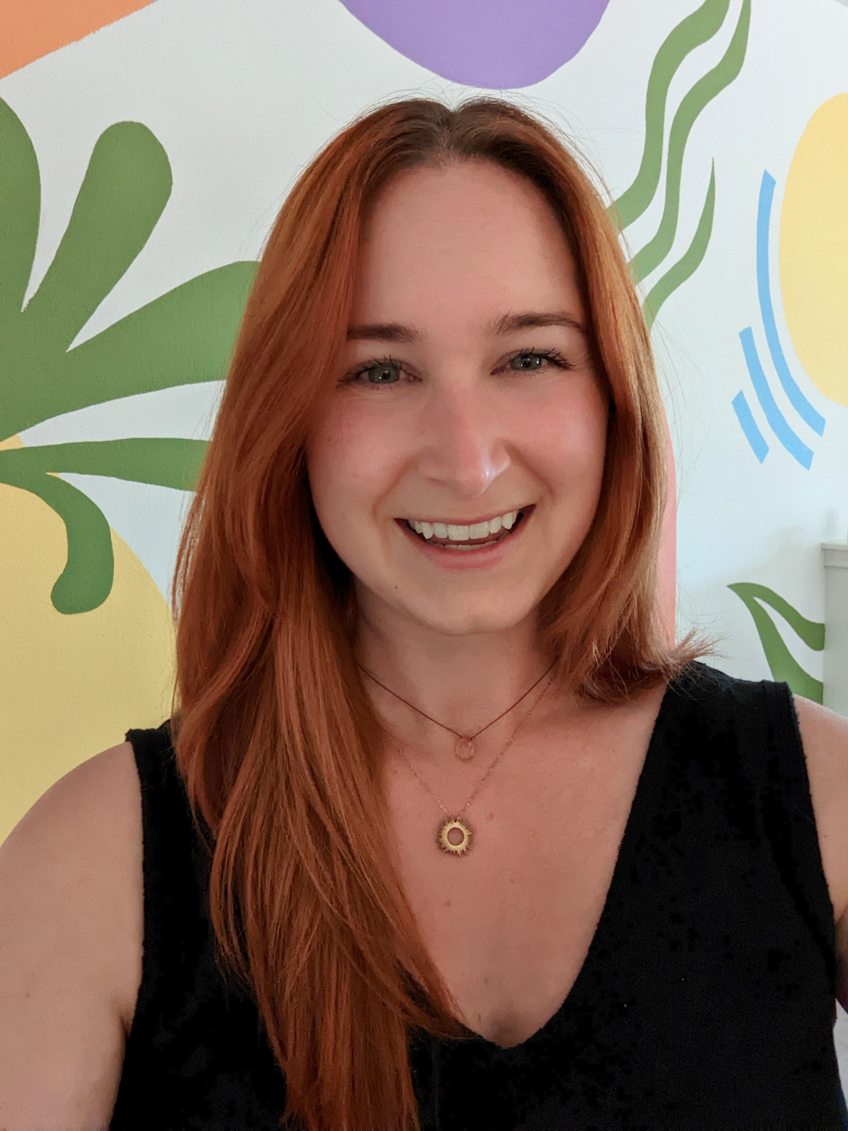 Page Grossman, copywriter and content strategist, in front of a mural she painted
